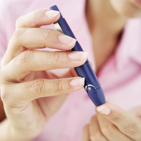 Woman Removing Blood from Her Finger for a Blood Test