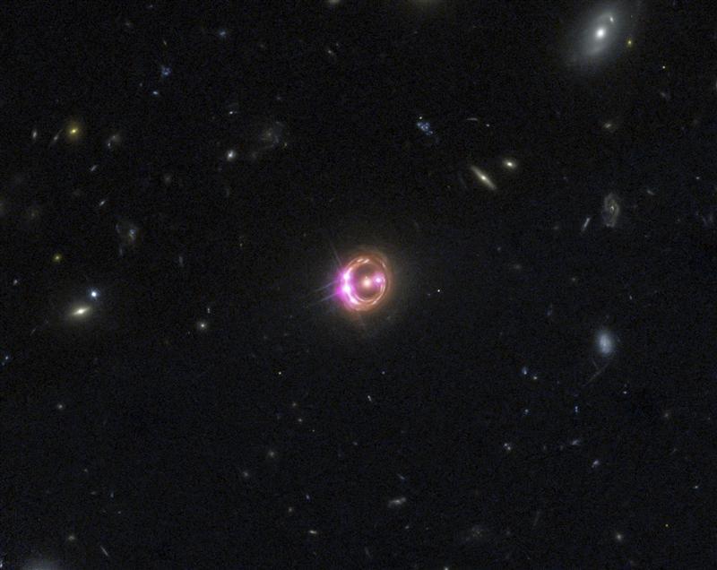 Multiple images of a distant quasar are visible in this undated combined view from NASA’s Chandra X-ray Observatory and the Hubble Space Telescope