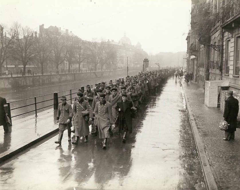 Prisioneiros de guerra da Polícia Militar alemã e agentes da Gestapo na cidade de Estrasburgo são levados a 3ª Divisão de Infantaria. Os prisioneiros estão sendo escoltados pelas Forças Francesas do Interior. 