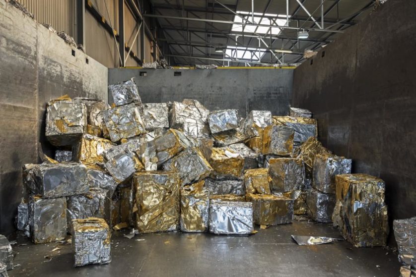 Recortes de alumínio são compactados em grandes blocos atados com laca de ouro usada para embalagem de latas de cerveja. Na fundição de uma reciclagem, a laca é queimada e o alumínio fundido é reconvertido em novos blocos que podem ser usados para produzir novas latas 