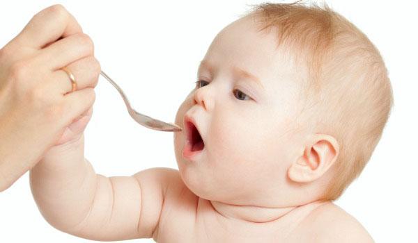 Little baby feeding with a spoon