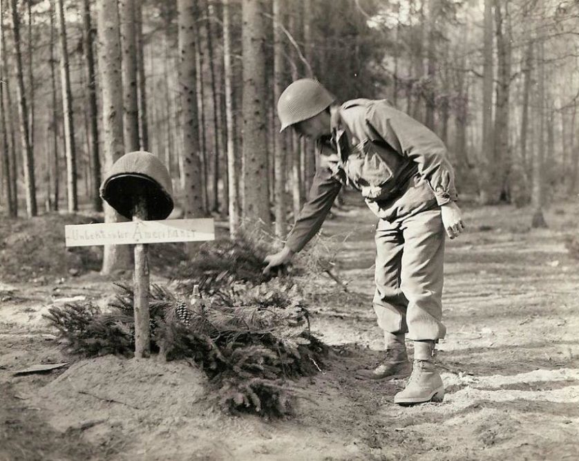 Um soldado americano examina o túmulo de outro soldado americano desconhecido, que foi enterrado pelo inimigo. O primeiro que notou o túmulo o decorou com morteiros e samambaias. 