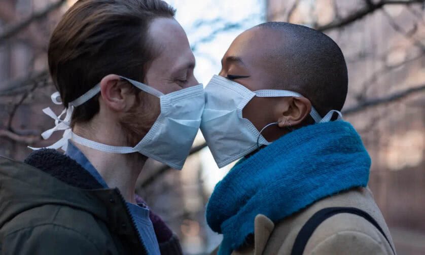 Casal se beijando com máscaras faciais durante a pandemia de Covid-19