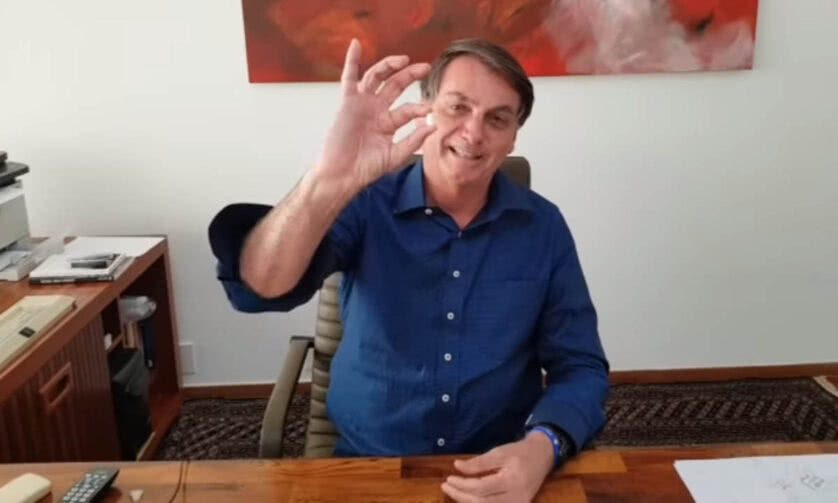 O presidente Bolsonaro segurando um comprimido de cloroquina