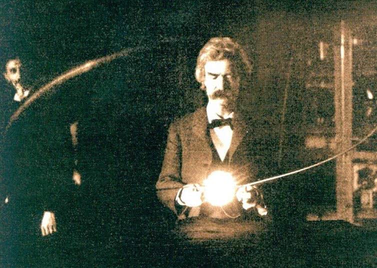 Mark Twain segurando a lâmpada de vácuo experimental de Nikola Tesla