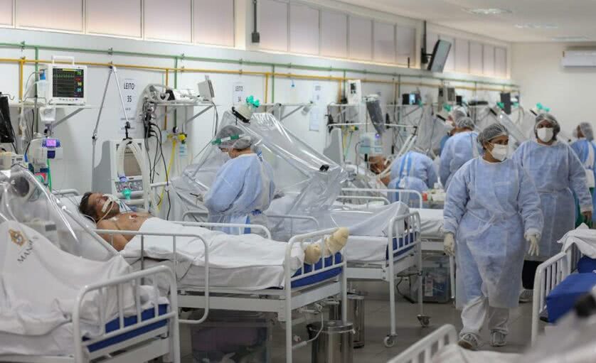 Enfermaria de hospital com pacientes e médicos